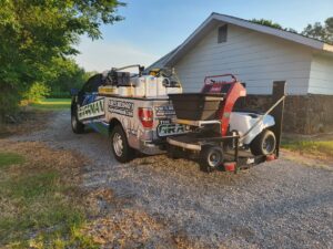 A professional lawn treatment truck with a sprayer and spreader, demonstrating services offered by A&B Lawn Services in Baytown, TX.