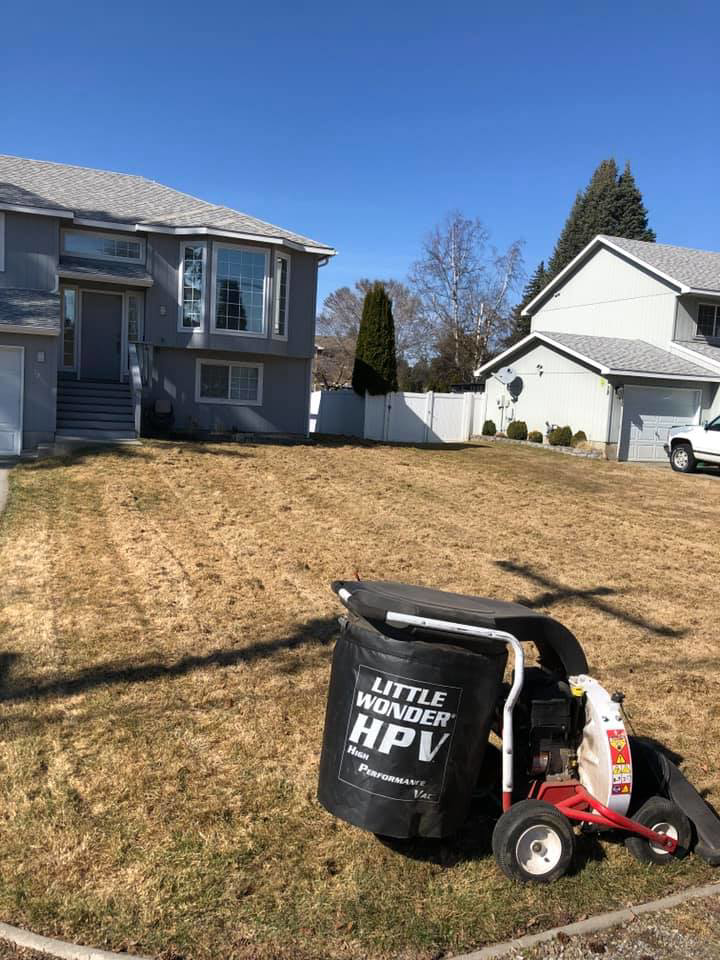 A powerful lawn vacuum machine on a residential property with dry grass, ready for cleanup by Cowboy Cutting LLC in Spokane, WA.