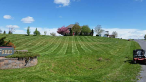 A professional lawnmower parked on a freshly mowed hillside, showcasing work by Clean Cuts Lawn Care in Cavetown, MD.