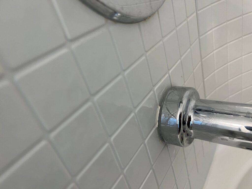 Water dripping from a leaking drain pipe into a floor drain, showing plumbing repair needs by McCutcheon & Sons Air Conditioning and Plumbing in Tempe, AZ