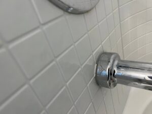 Water dripping from a leaking drain pipe into a floor drain, showing plumbing repair needs by McCutcheon & Sons Air Conditioning and Plumbing in Tempe, AZ