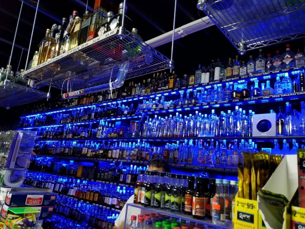 Blue LED strip lighting installed on shelves in a liquor store by MDEC Electrical & Lighting in Livonia, MI.