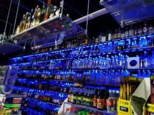 Blue LED strip lighting installed on shelves in a liquor store by MDEC Electrical & Lighting in Livonia, MI.