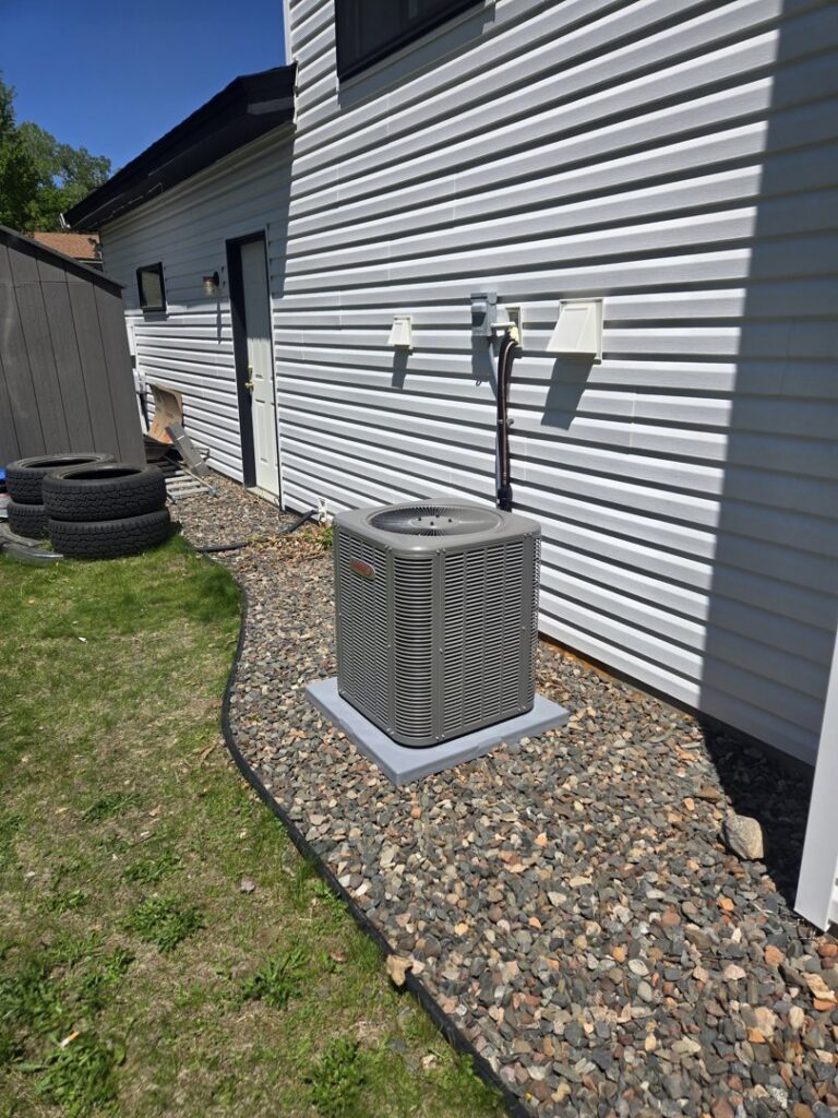 A newly installed Lennox air conditioning unit on the side of a house by Cyber Heating and Cooling in Bloomington, MN.