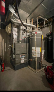 A Lennox furnace and water heater with ductwork and piping in a utility area by EPIC Heating and Air in Loveland, CO