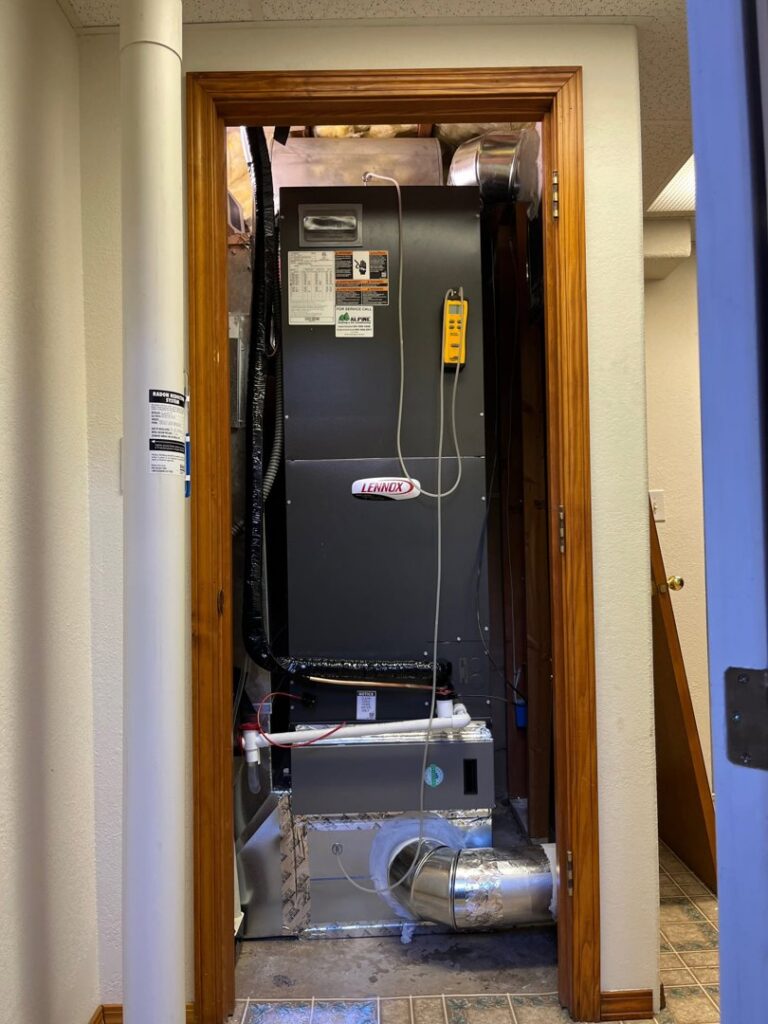 A Lennox furnace installed in a utility closet, being serviced by Alpine Heating in Eugene, OR.