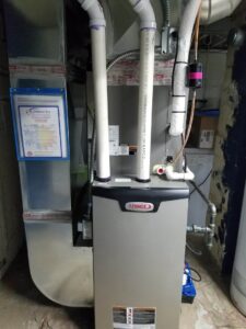 A newly installed Lennox furnace with ductwork and an R.J. Nelson Co service certificate in Council Bluffs, IA.