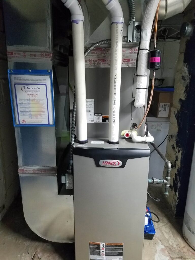 A newly installed Lennox furnace with ductwork and an R.J. Nelson Co service certificate in Council Bluffs, IA.