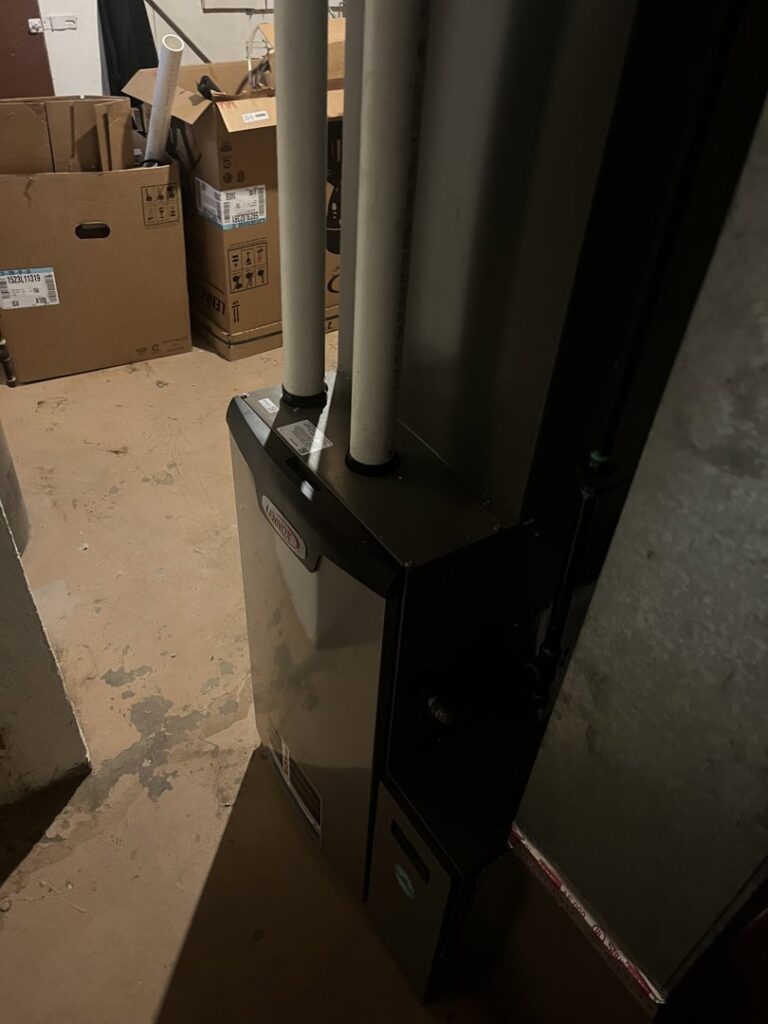 A Lennox furnace unit with PVC venting pipes, indicating a professional HVAC installation by Crain Heating and Cooling in Jeffersonville, IN.