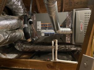 A Lennox HVAC furnace unit and ductwork installed in an attic by Rhino Heating and Air Conditioning LLC, serving Norman, OK.
