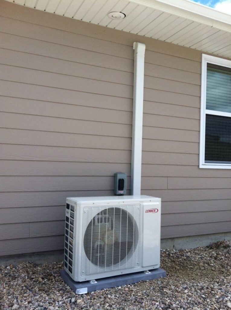 A Lennox mini-split outdoor condenser unit installed on the side of a house by JM HVAC Pros in Elgin, IL.