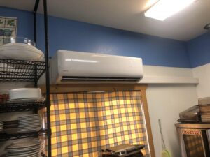A white Lennox mini-split HVAC unit installed above a kitchen window by Butte Tin Shop, Inc. in Butte, MT.