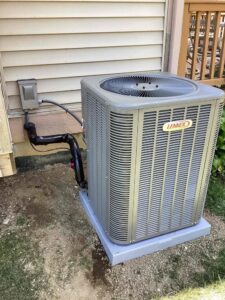 A new Lennox outdoor air conditioning unit installed next to a residential building by Terry Allen Plumbing & Heating in Flint, MI.