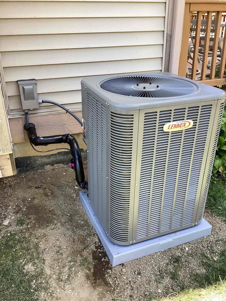 A new Lennox outdoor air conditioning unit installed next to a residential building by Terry Allen Plumbing & Heating in Flint, MI.