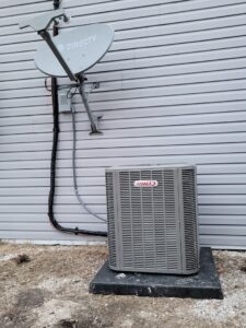 A newly installed Lennox outdoor AC unit next to a residential building by Trade Allies Heating and Cooling in Ankeny, IA.