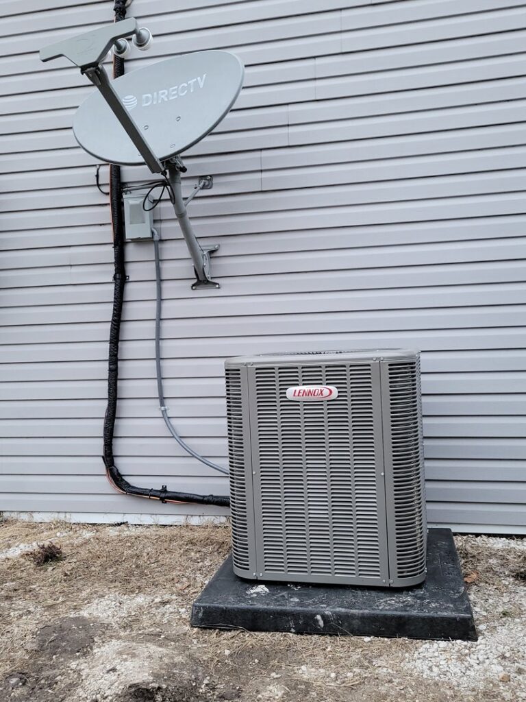 A newly installed Lennox outdoor AC unit next to a residential building by Trade Allies Heating and Cooling in Ankeny, IA.