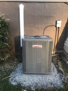 A Lennox outdoor air conditioning unit installed on a gravel bed by Strine's Heating & A/C in York, PA.