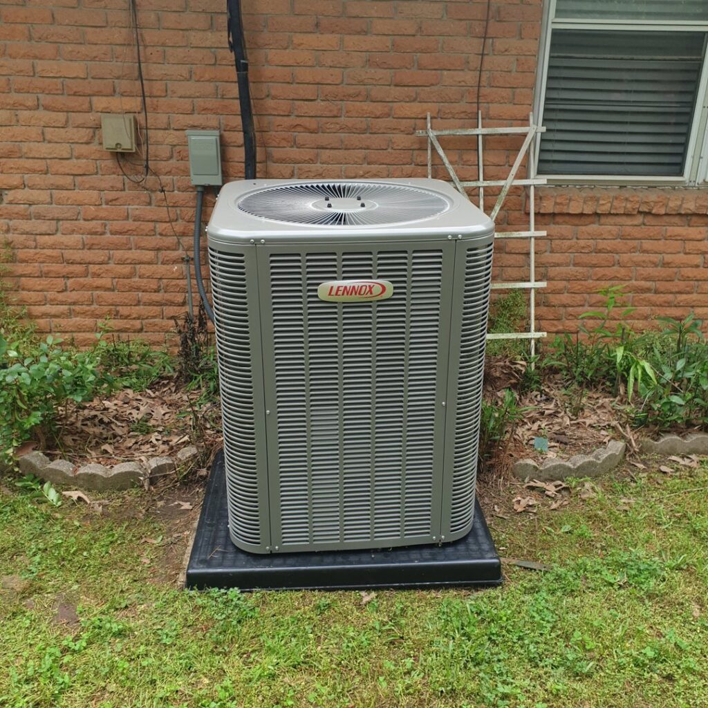 A Lennox outdoor HVAC condenser unit installed next to a residential brick house by Home Shield Heating and Air in Shreveport, LA.