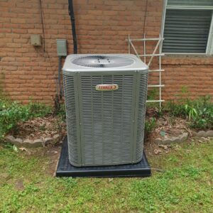 A Lennox outdoor HVAC condenser unit installed next to a residential brick house by Home Shield Heating and Air in Shreveport, LA.