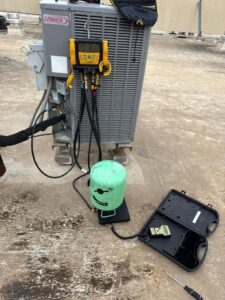 A Lennox rooftop HVAC unit being serviced with diagnostic tools and a refrigerant tank by Jupitair in Frisco, TX.