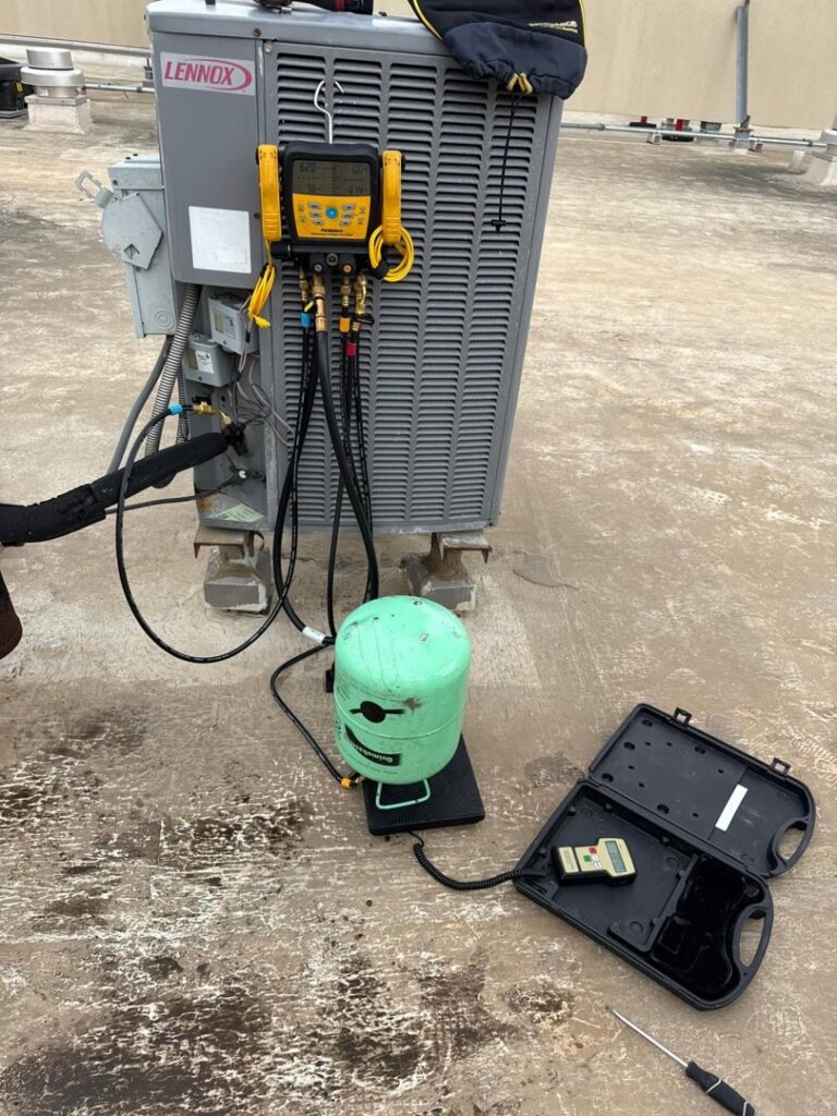 A Lennox rooftop HVAC unit being serviced with diagnostic tools and a refrigerant tank by Jupitair in Frisco, TX.