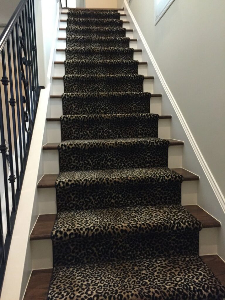A stylish leopard print carpet runner professionally installed on a staircase by All Surfaces Wholesale in Houston, TX.