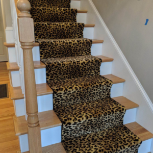 A newly installed leopard print carpet runner on a wooden staircase by Metro Floor Covering Inc. in Livonia, MI