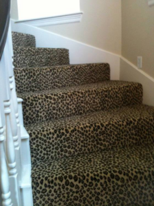 A staircase featuring a stylish leopard print carpet installed by Floors For Living - Meyerland in Houston, TX.