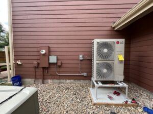 A newly installed LG heat pump outdoor unit next to a home, expertly placed by Just Heat Pumps in Denver, CO.
