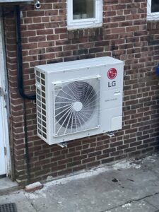An LG mini-split condenser unit installed on a brick wall by Freedom Air Mechanical Contractors LLC in Everett, MA.