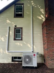 An LG mini-split outdoor unit installed next to a house by P3 Mechanical Heating & Cooling in Bainbridge, PA.
