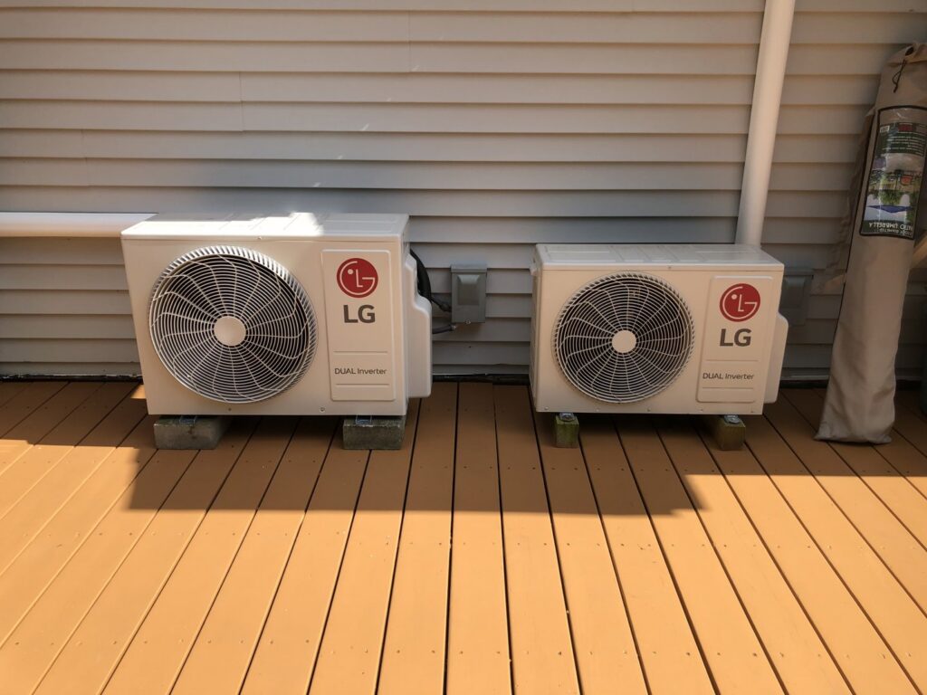 Two LG mini-split outdoor units professionally installed on a wooden deck by Garrison City HVACR in Dover, NH