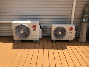 Two LG mini-split outdoor units professionally installed on a wooden deck by Garrison City HVACR in Dover, NH