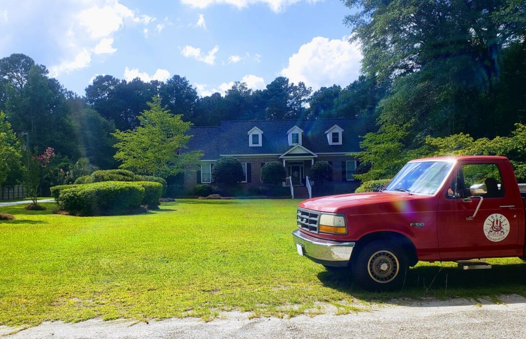 A Liberty LAWN Care truck parked in front of a beautifully maintained property, reflecting quality service in Sumter, SC.