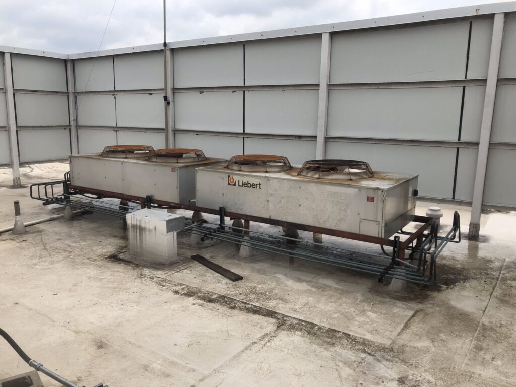 Large Liebert commercial HVAC units on a rooftop, serviced by Raleigh Comfort Services in Raleigh, NC.
