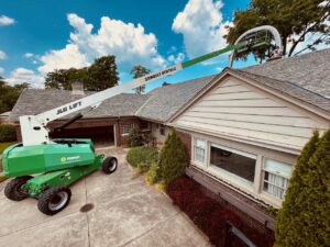 A lift bucket extended over a residential house, positioned for chimney service or repair by Century Chimney Sweep and Repair in Cleveland, OH