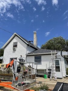 A lift and ladder set up at a house for high-access wildlife exclusion work by Prairie Bat Services, LLC in Sioux Falls, SD.