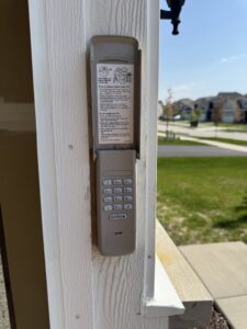 A LiftMaster garage door keypad installed on a door frame by BSD Garage Door in Naperville, IL