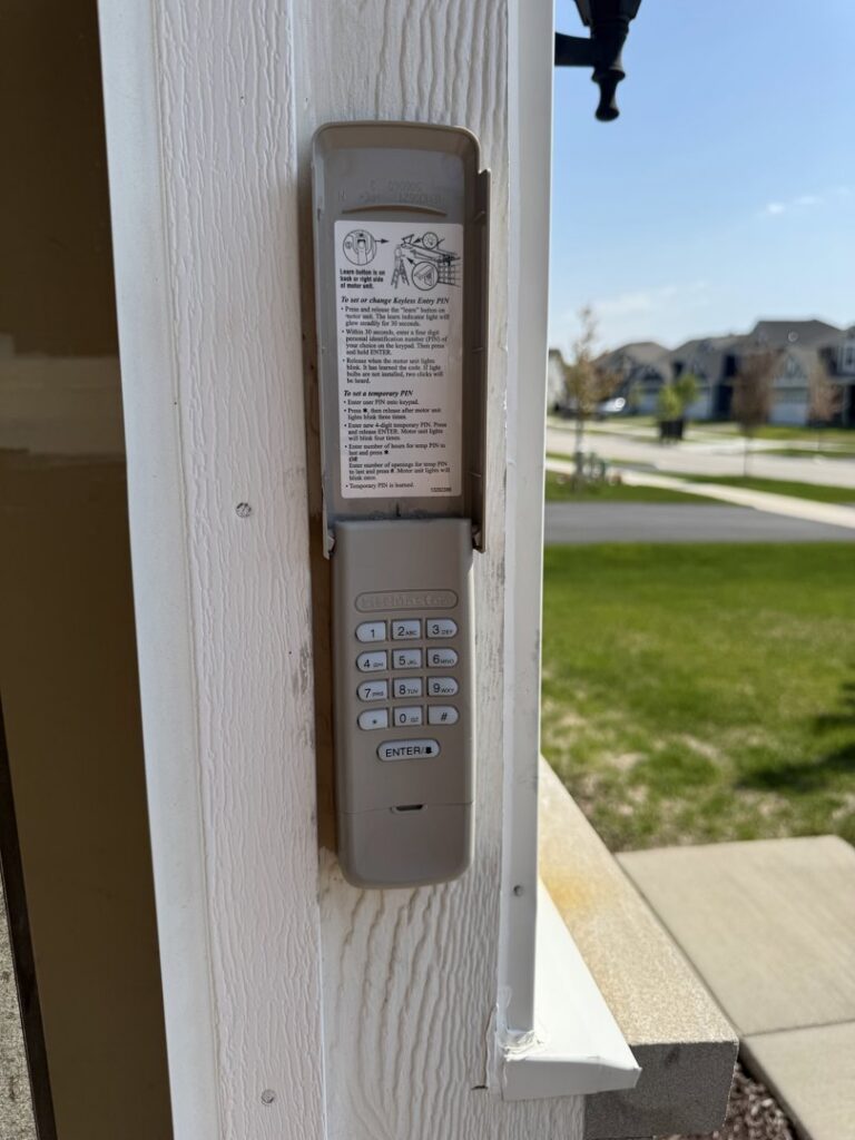 A LiftMaster garage door keypad installed on a door frame by BSD Garage Door in Naperville, IL