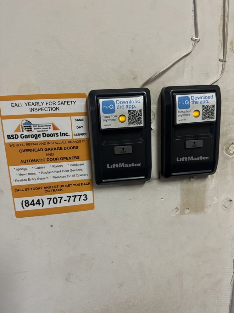 Two LiftMaster garage door opener wall controls and a service sticker from BSD Garage Door in Naperville, IL