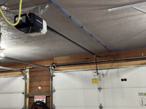 A LiftMaster garage door opener and tracks installed in a garage by AJK Door Services in Duluth, MN.