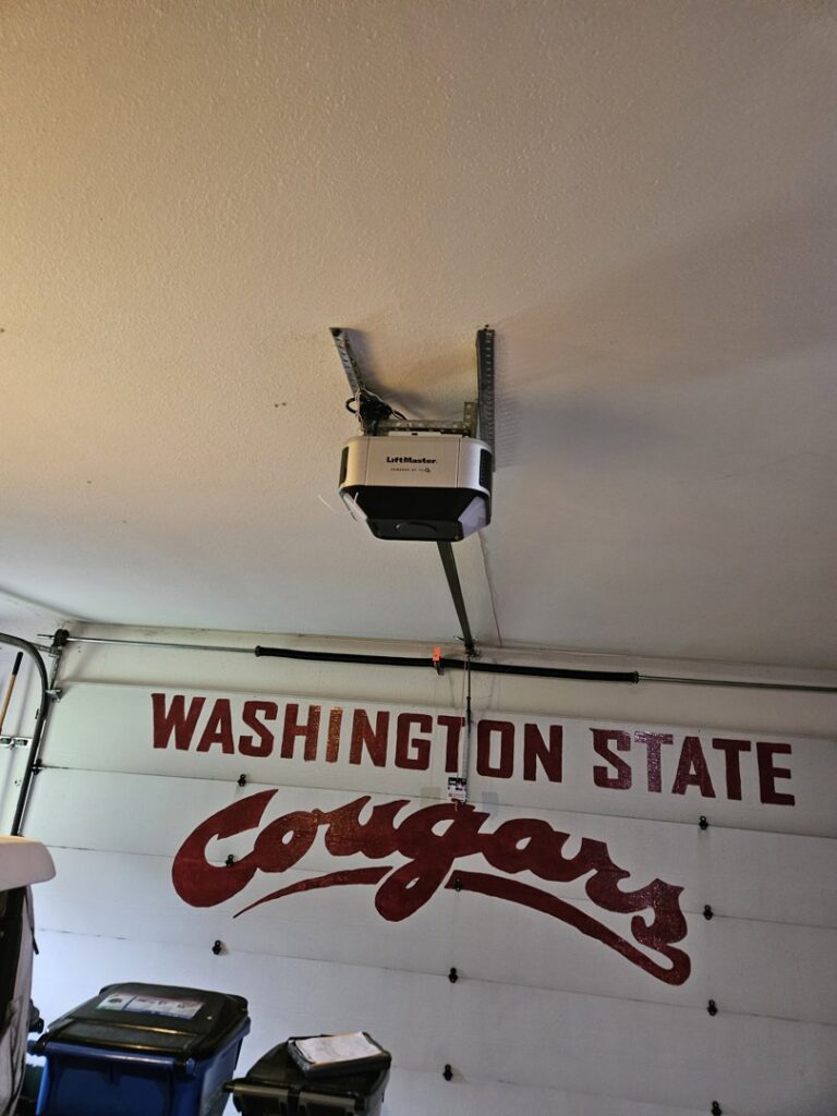 A LiftMaster garage door opener installed on the ceiling above a garage door by Babcock Garage Doors in Vancouver, WA