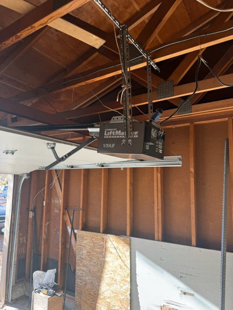 A LiftMaster garage door opener and track system installed inside a garage by Colorado Garage Door Guy in Aurora, CO.
