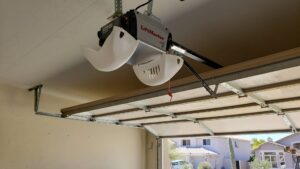 A close-up view of a LiftMaster garage door opener and the top panel of a garage door, installed by Johns Garage Doors in Tucson, AZ.