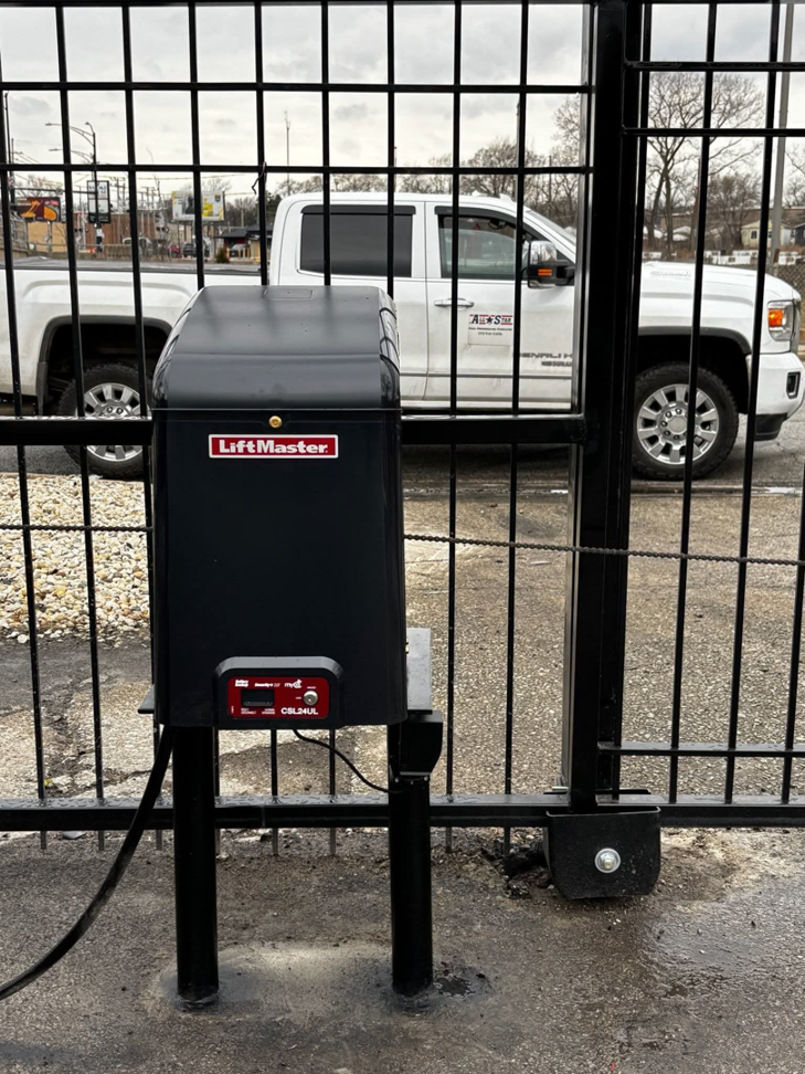 A close-up of a LiftMaster gate opener mechanism installed on a black metal gate by ALL STAR FENCE in Chicago, IL.