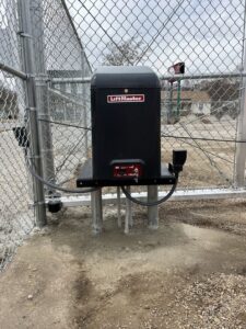 A LiftMaster gate operator installed on a chain-link fence by Brothers Gate Operators and Services LLC in Olathe, KS.