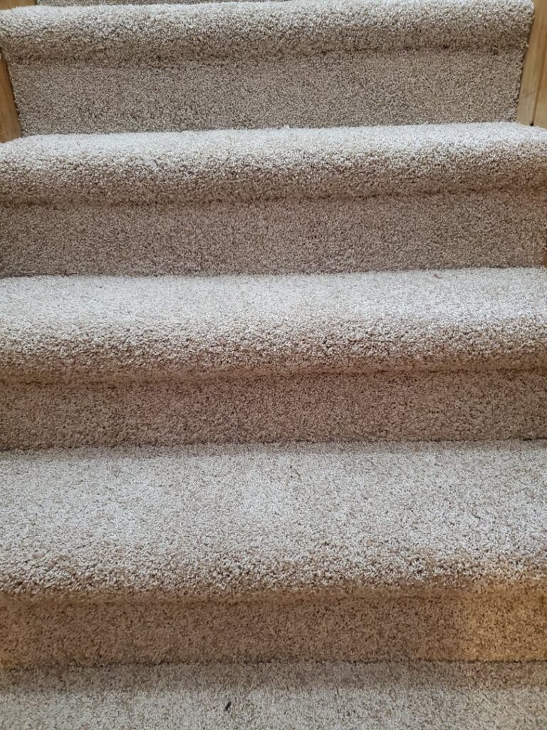 A beautifully installed light beige carpeted staircase by The Floor Store Inc. in Scranton, PA.