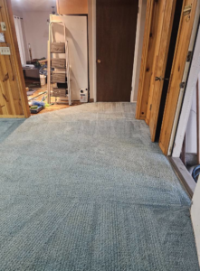 A light blue carpet with cleaning lines, showing equipment in the background from Super Clean Carpet Cleaning in Idaho Falls, ID.