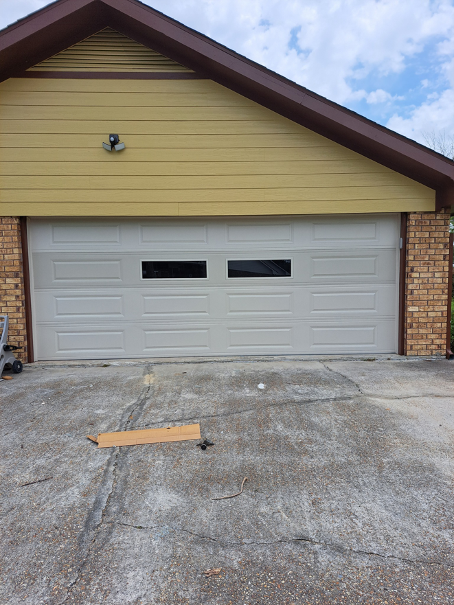 A light-colored garage door with two rectangular windows installed by Residential WorX LLC in Westlake, LA.