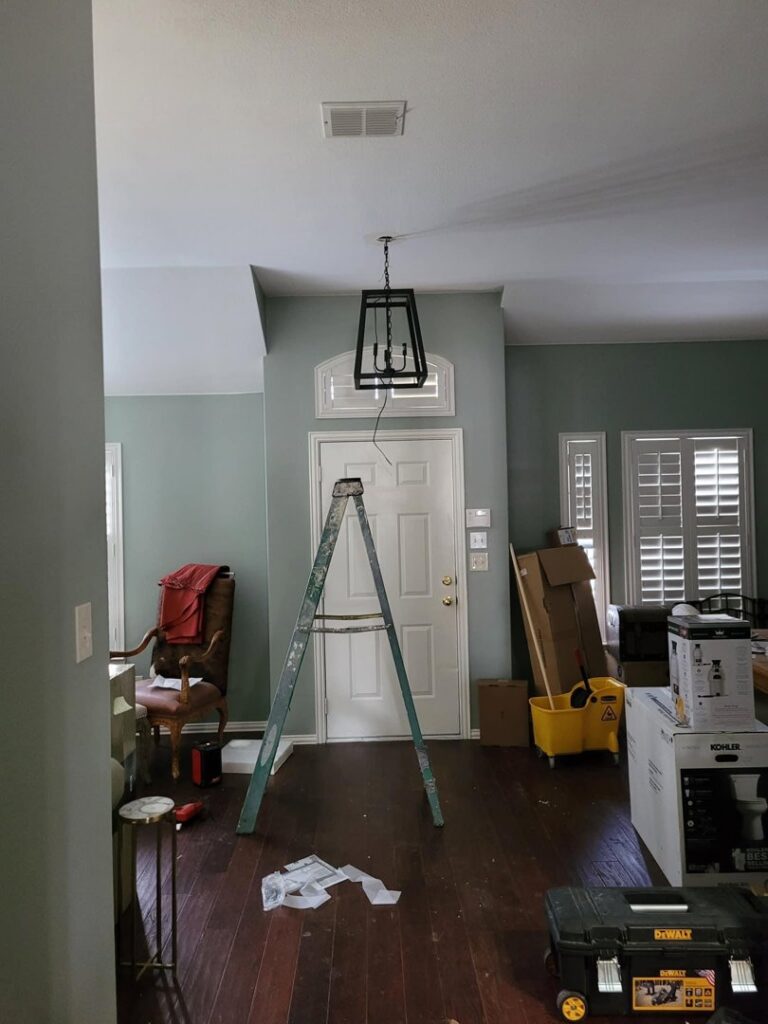 A new light fixture being installed or replaced from a ladder, showing electrical work by Quistian Lighting in Arlington, TX